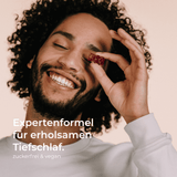 Mann hält yuicy-Gummibärchen vor sein Gesicht und lacht. Folgender Text steht auf dem Bild: "Expertenformel für erholsamen Tiefschlaf. zuckerfrei und vegan."
